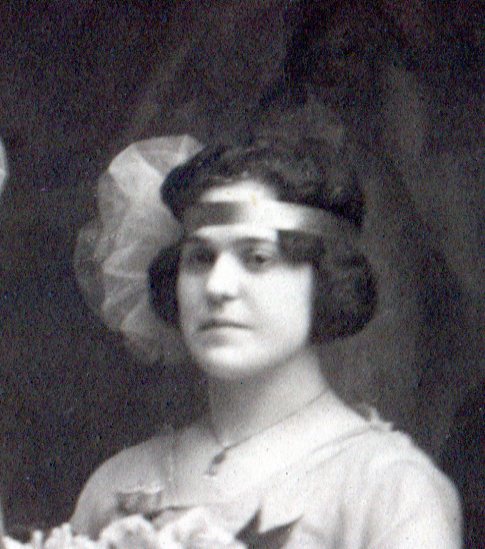 Close up of bridesmaid's headpiece of ribbon around head with large netting puff on right side of head.