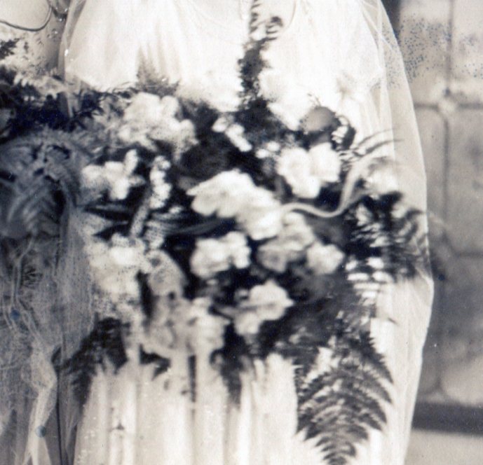 Bride's bouquet of white flowers and large fern fronds.