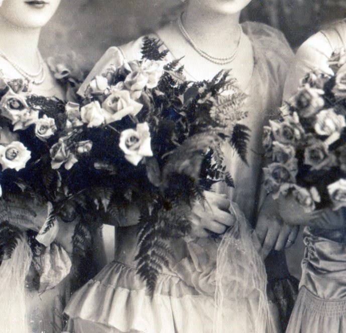 Bridesmaid's large bouquets of large flowers and greens and fern fronds.