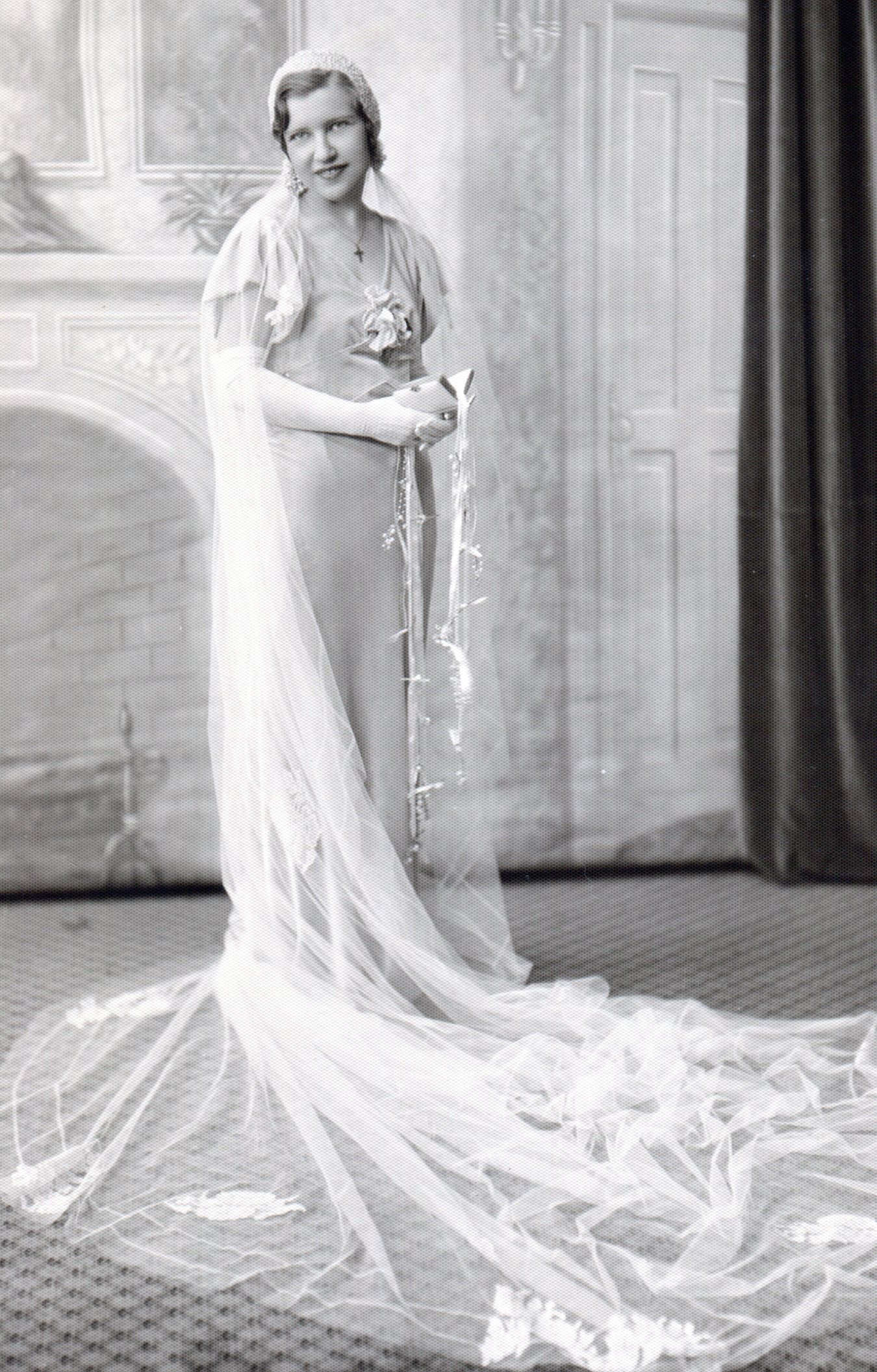 Bride in long slinky white satin dress and long veil