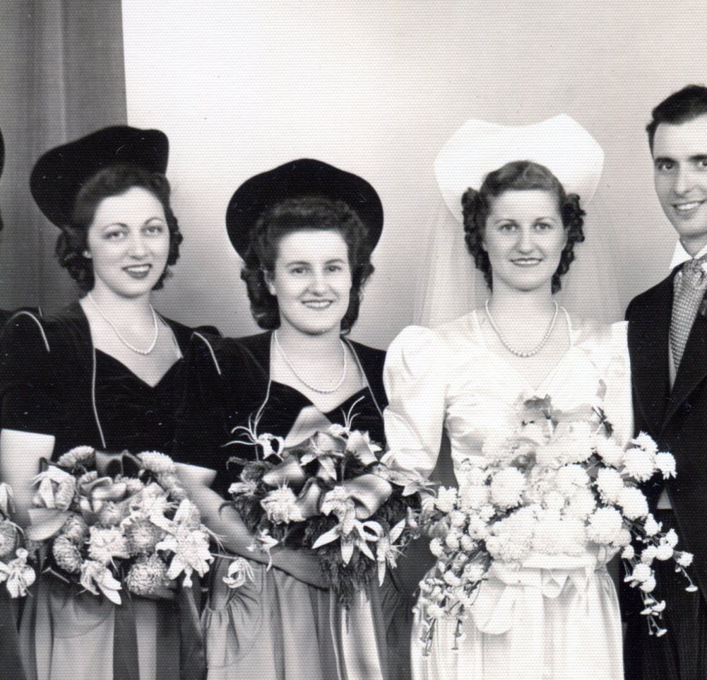 Close up of Bride's hat made of satin covered millnery mesh which stands up about 5 inches above her head.