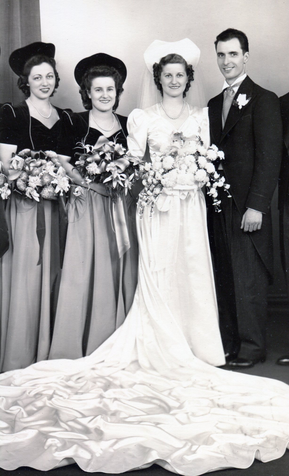 Bride's white satin dress with Sweet Heart neckline , train, large hat as bridal headpiece with veil and bouquet.