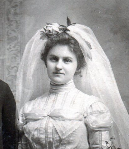 Close up of Bride with bridal veil attached at top of her up-swept hair.