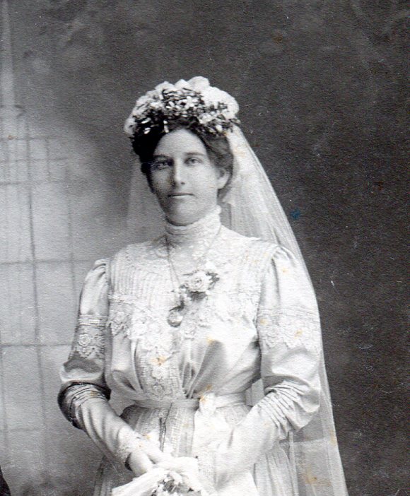 Bridal dress top showing various kinds of lace as decoration on bodice and long sleeves.