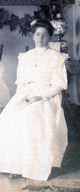 Maid-of-Honor in white or pale dress with slightly puffy bodice, long sleeves puffy to the elbow, and long gathered skirt .