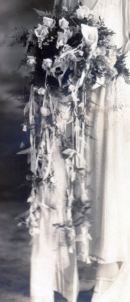 Bridal bouquet with "water fall" of ribbons with flower buds tied on hanging down from the bouquet.