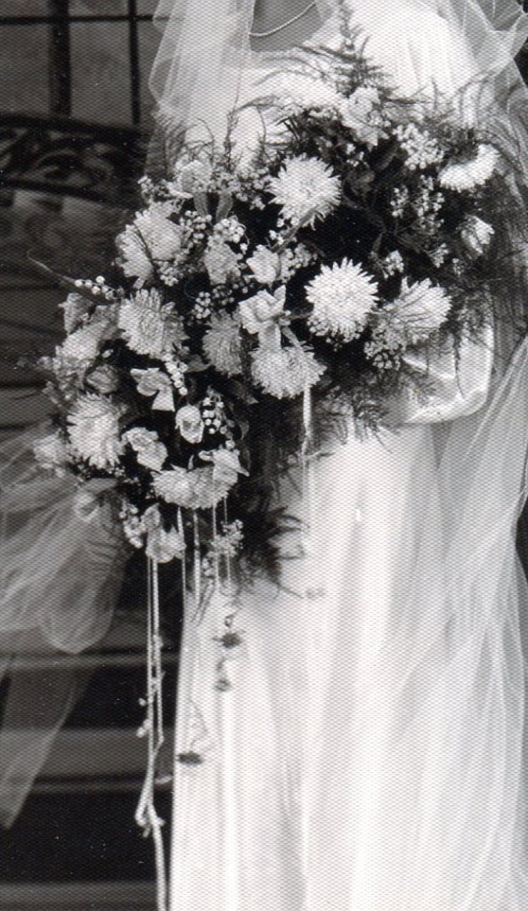 Large bridal bouquet of Shasta Daisies and small roses.
