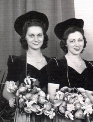 Two bridesmaids with dark velvet caps similar to the bride's cap, and bouquets of Star lilies.