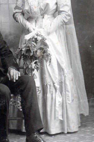 Bridal gown slightly gathered skirt with wide ruffle at bottom topped with lace.