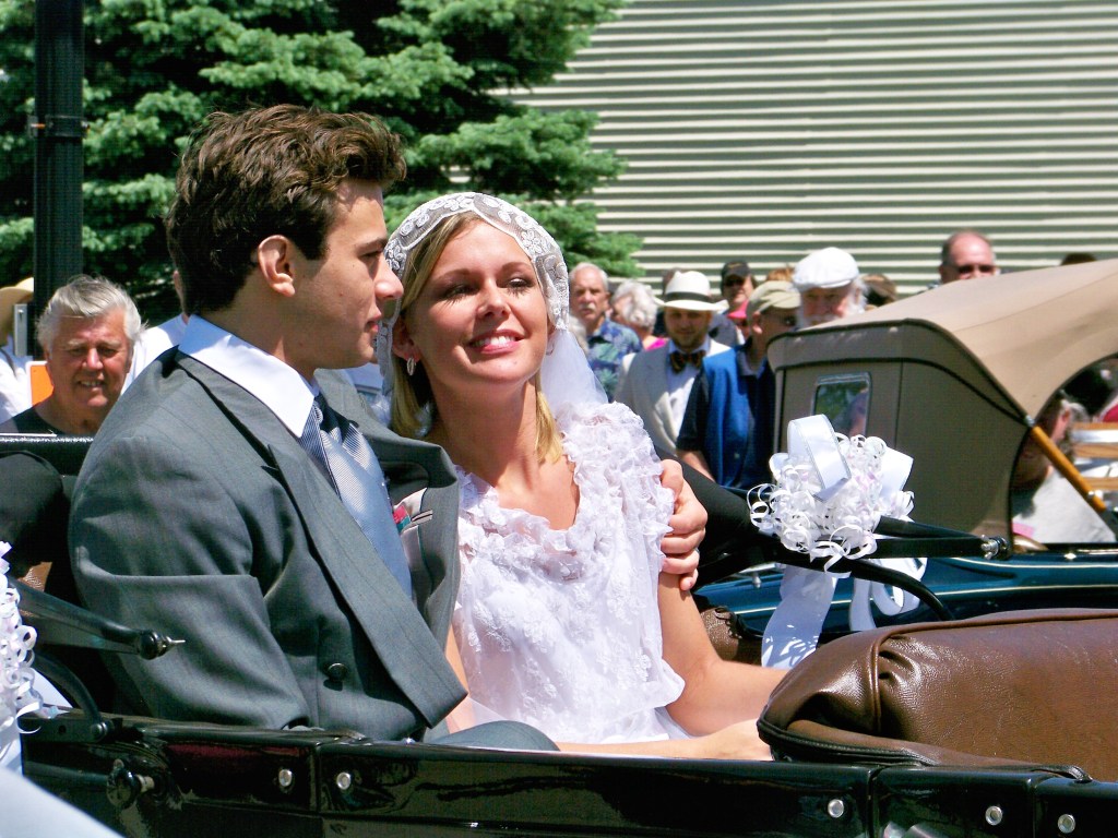 Bride and Groom sitting in back seat of Model A Ford convertible.
