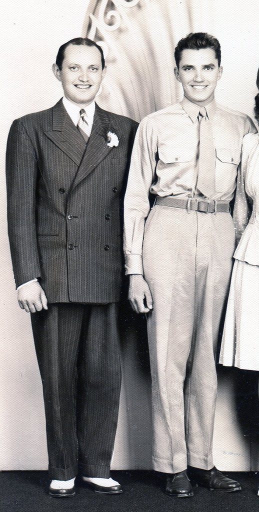 The Soldier-Groom wears his Army uniform and the Best Man, standing next to him, wears a pin-striped double-breasted suit that was typical of the late 1930s.