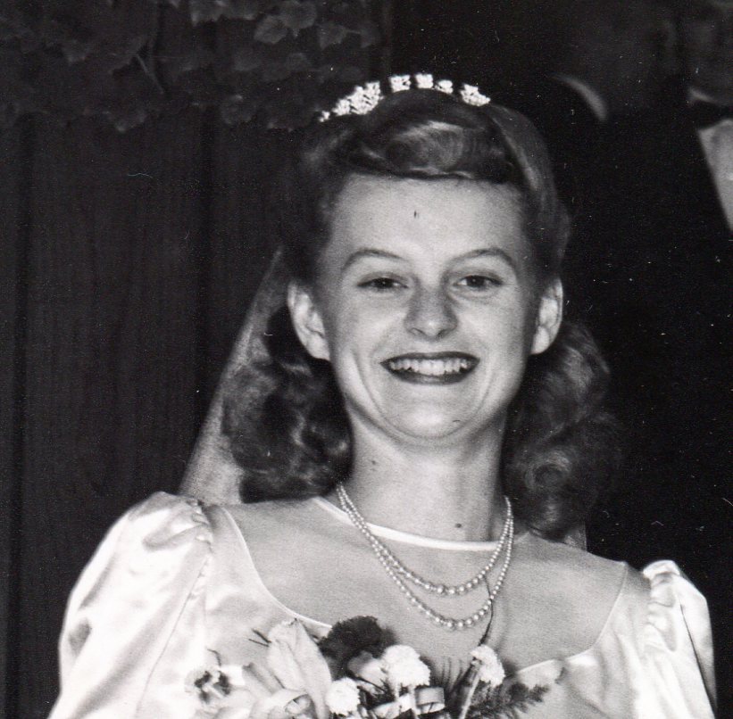 Bridal headpiece shows above Bride's hair as ruffle of netting.